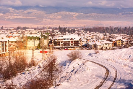Houses with snow roofs pink sunset panorama of bulgarian ski resort Bansko, Bulgariaの写真素材