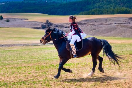 Bachevo, Bulgaria - March 16, 2019: Horse Easter or the day of Todor in Bulgaria, lady in traditional bulgarian clothing riding a horse in the mountainsのeditorial素材