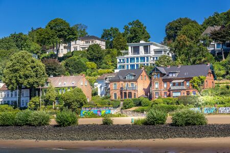 Hamburg, Germany - July 26, 2018: Houses view on the bank of Elbe river, green trees and blue skyのeditorial素材
