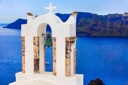 Sea and iconic view of white church bell tower, Santorini, Oia, Greece