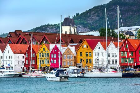 Bergen, Norway - July 30, 2018: City street panoramic banner of Bryggen, boats and colorful traditional nordic housesのeditorial素材