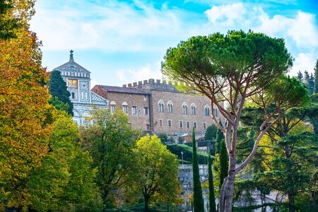 Abbazia di San Miniato al Monte basilica on the top of the hill in Florence, Italy. Autumn trees and pines aroundの写真素材