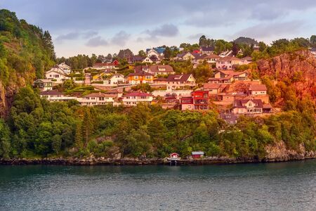Evening village panorama near Bergen, Norway with colorful traditional scandinavian houses and fjord waterの写真素材