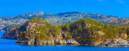 Norwegian landscape with fjord water, mountains and lighthouse, Norway, banner panoramic backgroundの写真素材