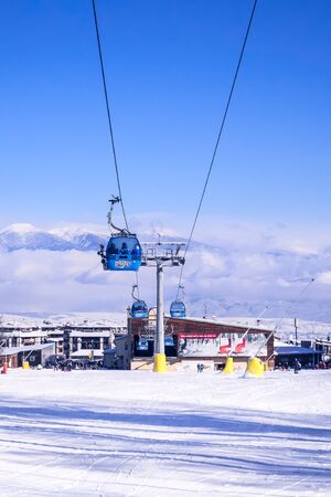 Bansko, Bulgaria - January 22, 2018: Bulgarian ski resort panorama with gondola ski lift cabin, slope and snow mountainsのeditorial素材