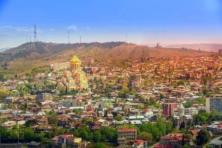 Tbilisi, Georgia aerial view with old traditional houses and Holy Trinity church or Tsminda Sameba...