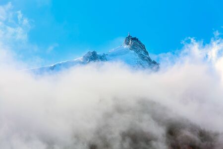 Aiguille du Midi peak between clouds, mountain in the Mont Blanc massif in the French Alps, Chamonix