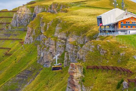 Grindelwald, Switzerland - October 10, 2019: Yellow cable car arriving from mountain village Wengen to viewpoint on cliff in Mannlichen, Bernese Oberlandのeditorial素材