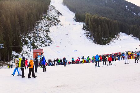 Bansko, Bulgaria - December 16, 2017: Kolarski ski lift at Banderishka polyana, skiers on ski slopes, mountain with pine trees, peopleのeditorial素材