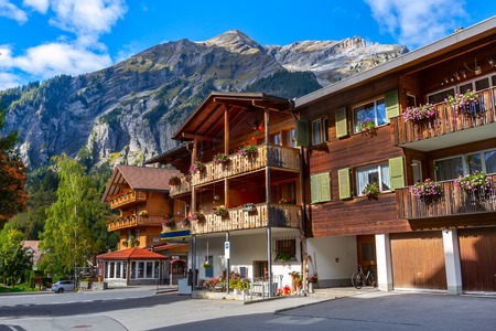 Kandersteg, Switzerland street view with colorful wooden houses in swiss village, flowers on balconies and mountains panoramaのeditorial素材