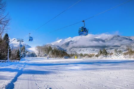 Bansko, Bulgaria - January 22, 2018: Bulgarian ski resort panorama with gondola ski lift cabin, slope and snow mountainsのeditorial素材