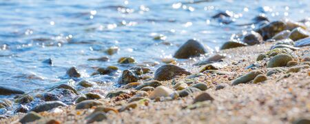 Sea stones background, ocean water edge at the beach coastの写真素材