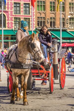 Bruges, Belgium - April 10, 2016: Horse carriage on market square in popular belgian destination Bruggeのeditorial素材