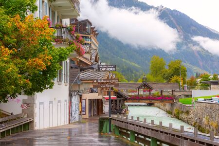 Chamonix Mont-Blanc, France - October 4, 2019: Street, river Arve and wooden bridge, decorated with colorful flowers, French Alpsのeditorial素材