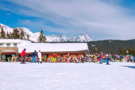 Saalbach-Hinterglemm, Austria - March, 1, 2020: People skiing and eating at the ski slope restaurant, outdoor cafe with tablesのeditorial素材