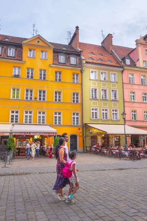 Wroclaw, Poland - June 21, 2019: Evening in Old Town Rynek Market Square, people and colorful houses