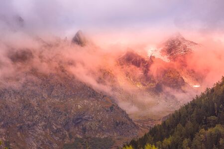 French Alps, Europe, fantastic evening snow mountain peaks landscape background. Colorful pink and...