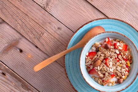 Bowl of delicious breakfast muesli with strawberry in blue ceramic bowl top viewの写真素材