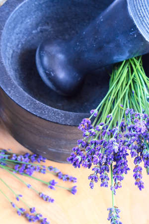 Pestle and mortar with lavender flowers on the tableの写真素材
