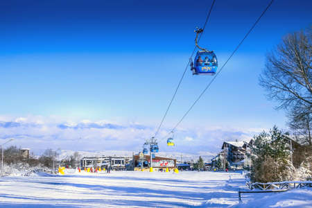 Bansko, Bulgaria - January 22, 2018: Winter ski resort with ski slope, cable car cabins, skiers and mountains viewのeditorial素材