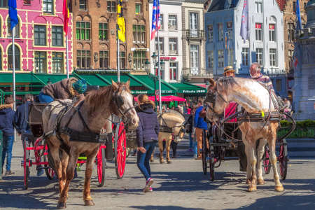 Bruges, Belgium - April 10, 2016: Horse carriage on market square in popular belgian destination Bruggeのeditorial素材