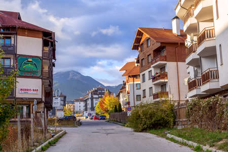 Bansko, Bulgaria - October 31, 2020: Autumn street and Pirin mountain view, houses and colorful treesのeditorial素材