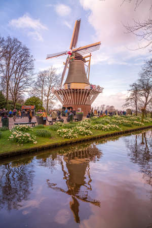 Lisse, Netherlands - April 4, 2016: Windmill and flowerbeds in the spring garden Keukenhof, peopleのeditorial素材