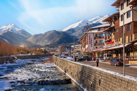Bansko, Bulgaria - January 28, 2021: Glazne river in bulgarian town, hotel houses and snow Pirin mountains peaksのeditorial素材