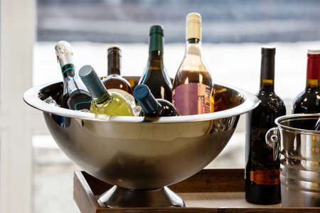 Bottles of wine and champagne in a metal bowlの写真素材
