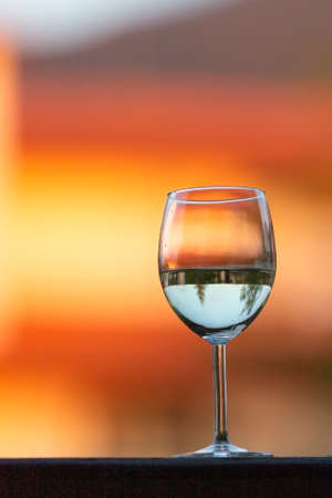 One white wine glass on the sunset blur backgroundの写真素材