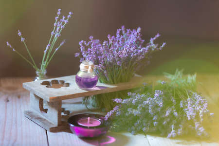 Herbal oil and lavender flowers still-life on wooden backgroundの写真素材