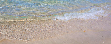 Background with coast line of sea, pebbles and sand under sea water at the beach