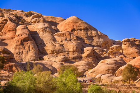 Petra, Jordan - November 3, 2022: People tourists walking along sandstone canyon, rocks formations in UNESCO World Heritage Siteのeditorial素材