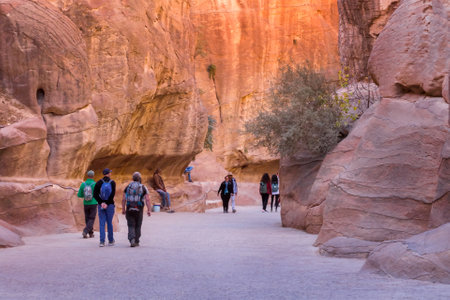 Petra, Jordan - November 3, 2022: People tourists walking along Siq walls to the Treasury, Al Khazneh, one of the new Seven Wonders of the Worldのeditorial素材