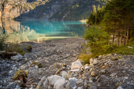 Oeschinensee lake in Switzerland in autumn, landscape photography, crystalic blue water, treesの写真素材