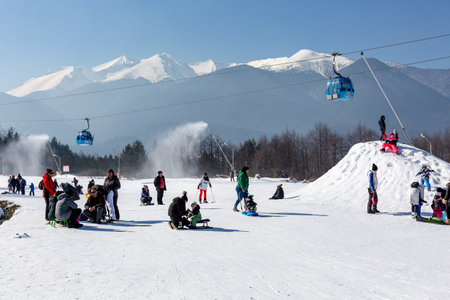 Bansko, Bulgaria - February 11, 2023: Bulgarian winter ski resort panorama with gondola lift cabins, Pirin mountain peaks view and slopeのeditorial素材