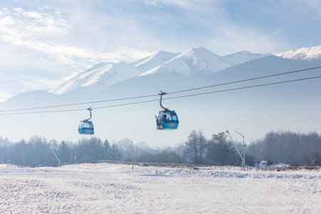 Bansko, Bulgaria - December 20, 2023: Bulgarian winter ski resort panorama with gondola lift cabin, Pirin mountain peaks viewのeditorial素材