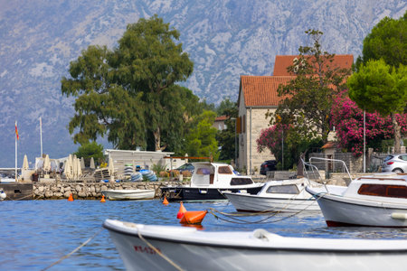 Kotor, Montenegro - September 20, 2023: Summer landscape with moored boats, Adriatic Sea and high mountainsのeditorial素材