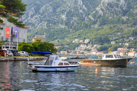 Kotor, Montenegro - September 20, 2023: Summer landscape with moored boats, Adriatic Sea and high mountainsのeditorial素材