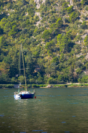 Kotor, Montenegro summer landscape with moored boat in Adriatic Sea and high mountains