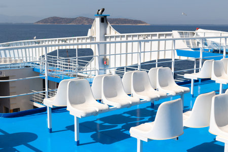 empty white seats on ferryboat terrace, port