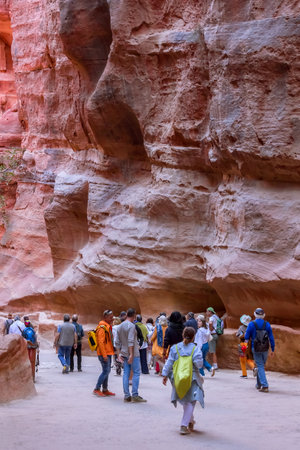 Petra, Jordan - November 3, 2022: People tourists walking along Siq walls to the Treasury, Al Khazneh, one of the new Seven Wonders of the Worldのeditorial素材