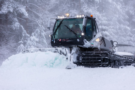 Bansko, Bulgaria - January 21, 2024: Snow groomer snowcat ratrack machine preparing ski slope for...