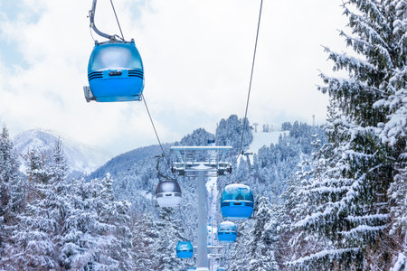 Bansko, Bulgaria winter ski resort panorama with blue gondola lift cabins, snow forest pine trees, mountain peaks slopes viewの写真素材