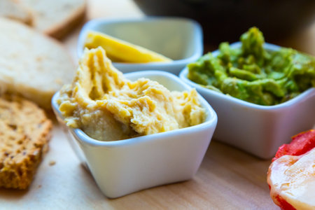 Various dip sauces in white bowls on wooden table