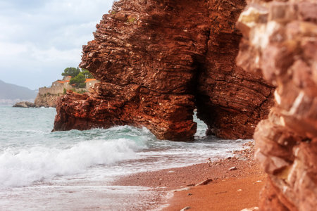 Wild beach Crvena Glavica in Montenegro. Red rocks coast arch at sunsetの写真素材