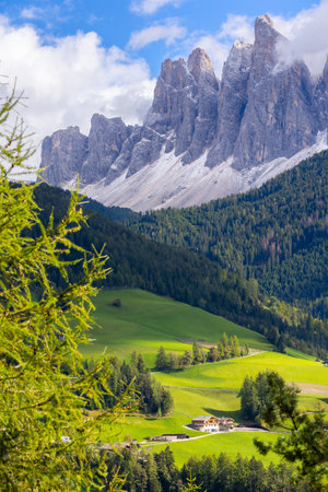 Aerial panoramic view of a village in the Dolomites, Italy, with green alpine meadows and mountains.の写真素材