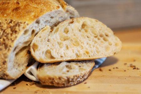 Homemade freshly bread and slices on kitchen table. Sourdough wheat rye loaf with seeds close-up viewの写真素材