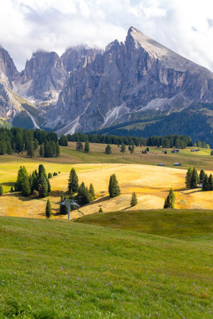 Dolomites Alpe di Siusi, Italy beautiful scenery, natural autumn landscape with house, Sassolungo mountain and meadowsの写真素材