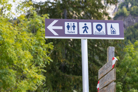 Arrow sign to church, toilet and photopoint in Santa Maddalena or Magdalena village in Dolomites mountains, Italyの写真素材